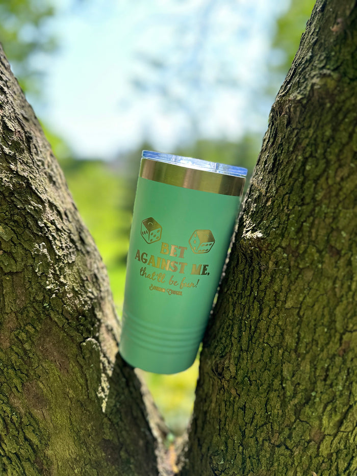 Green tumbler with gold text in tree.