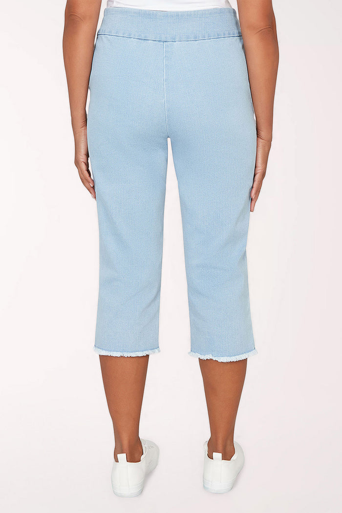 Woman wearing a light denim crop pant.