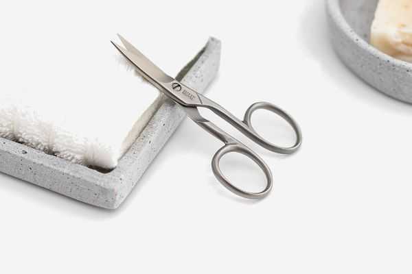 Elegant stainless steel nail scissors on tray