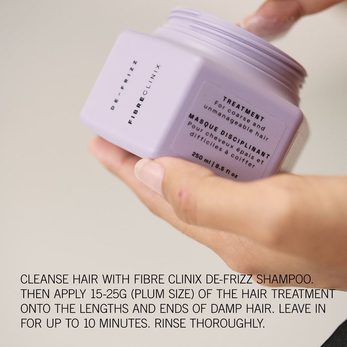 Hand holding Fibre Clinix hair treatment jar with application instructions along the bottom.