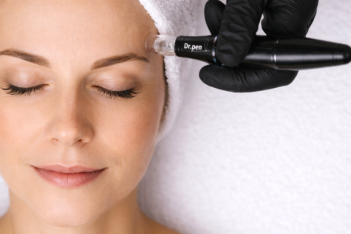 Woman receiving a facial treatment with a device labeled 'Dr. pei' on her face.