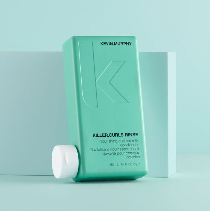Kevin Murphy Killer Curls Rinse conditioner in a 250ml bottle in front of a light blue background.