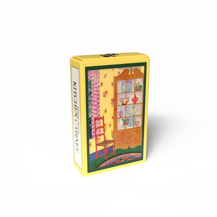 A yellow rectangular box features a vintage illustration of a red chair and dish-filled kitchen cabinet against a floral yellow wall. "Kitchen Cabinet | 99 Piece Jigsaw Puzzle" by Penny Puzzle is written on the side.