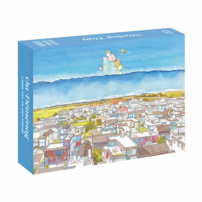 The WEVE Moving Day 1,000 Piece Jigsaw Puzzle features an illustrated cityscape with houses, mountains, and a trumpet-playing character floating above. Made with premium blue board for extra durability.