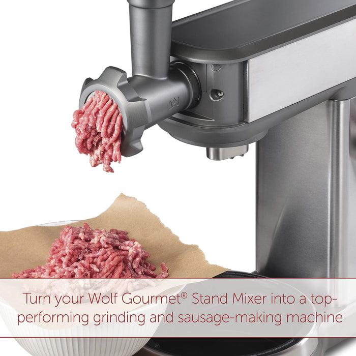 Wolf Gourmet High Performance Stand Mixer Food Grinder Attachment grinding meat and description about grinder's performance displayed on a white background