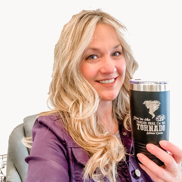 Woman holding a black tumbler with a tornado graphic.