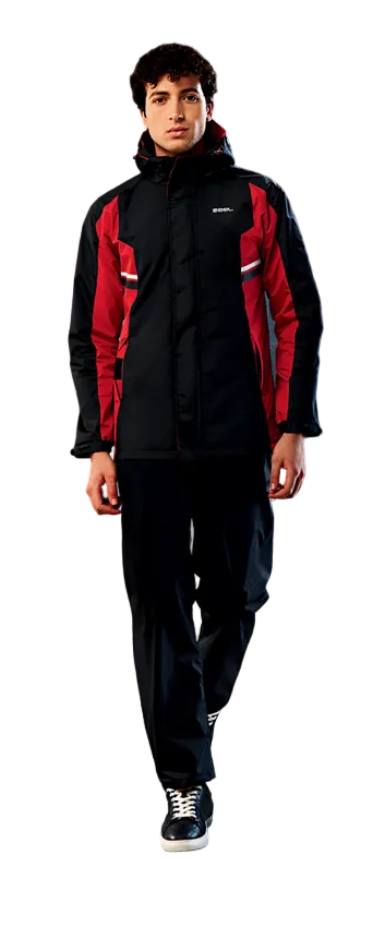 Person wearing a red and black rain suit with product features highlighted on a dark, rainy street background.